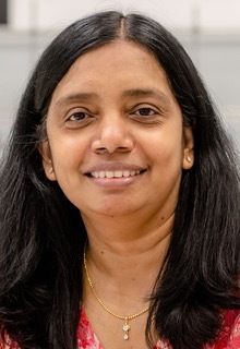 Porträt von Anjana Devi mit langen dunklen Haaren, sie lächelt leicht und blickt in die Kamera.